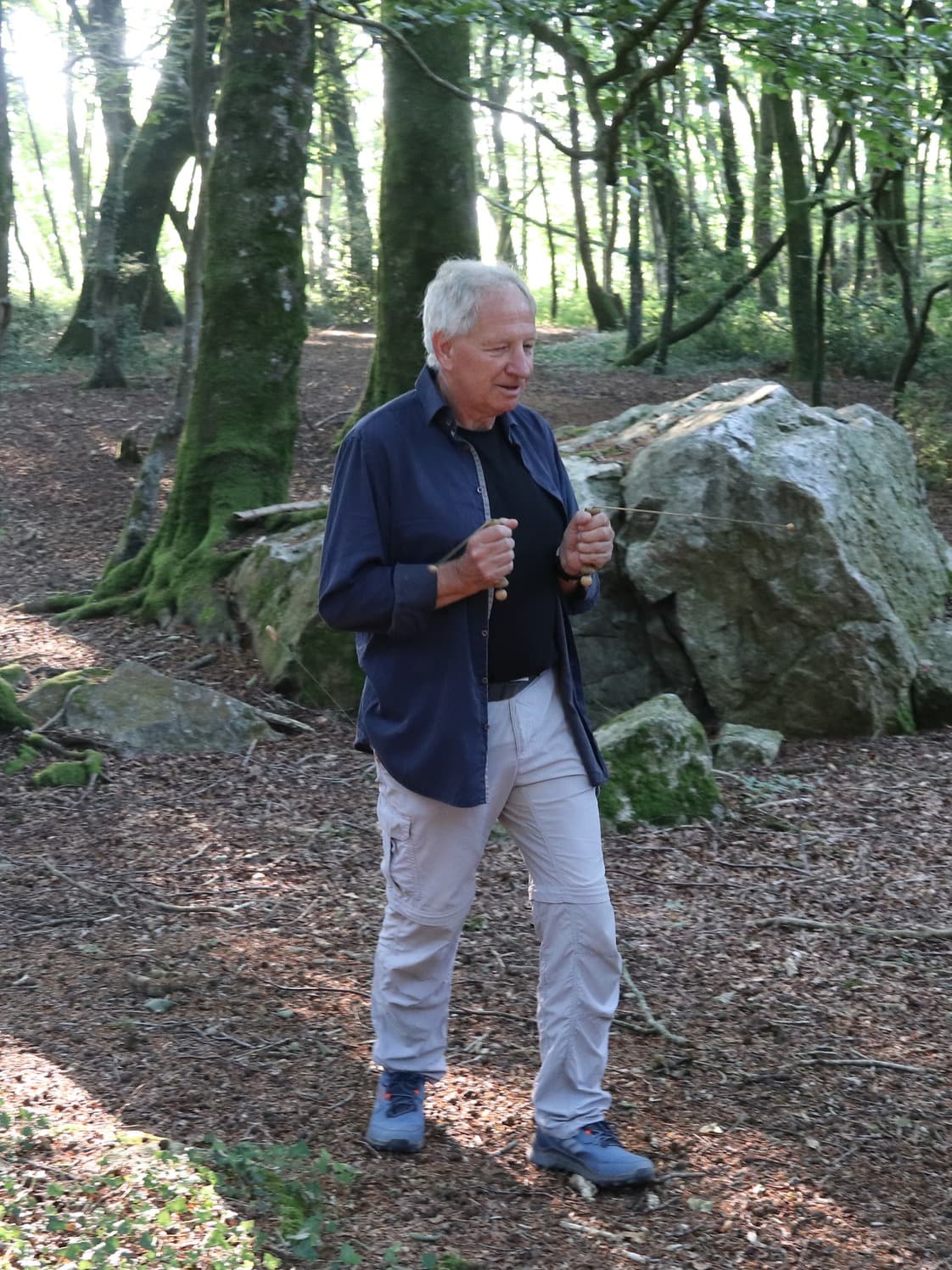 Jan werkt met de tensor tussen de bomen en rotsblokken van het bos