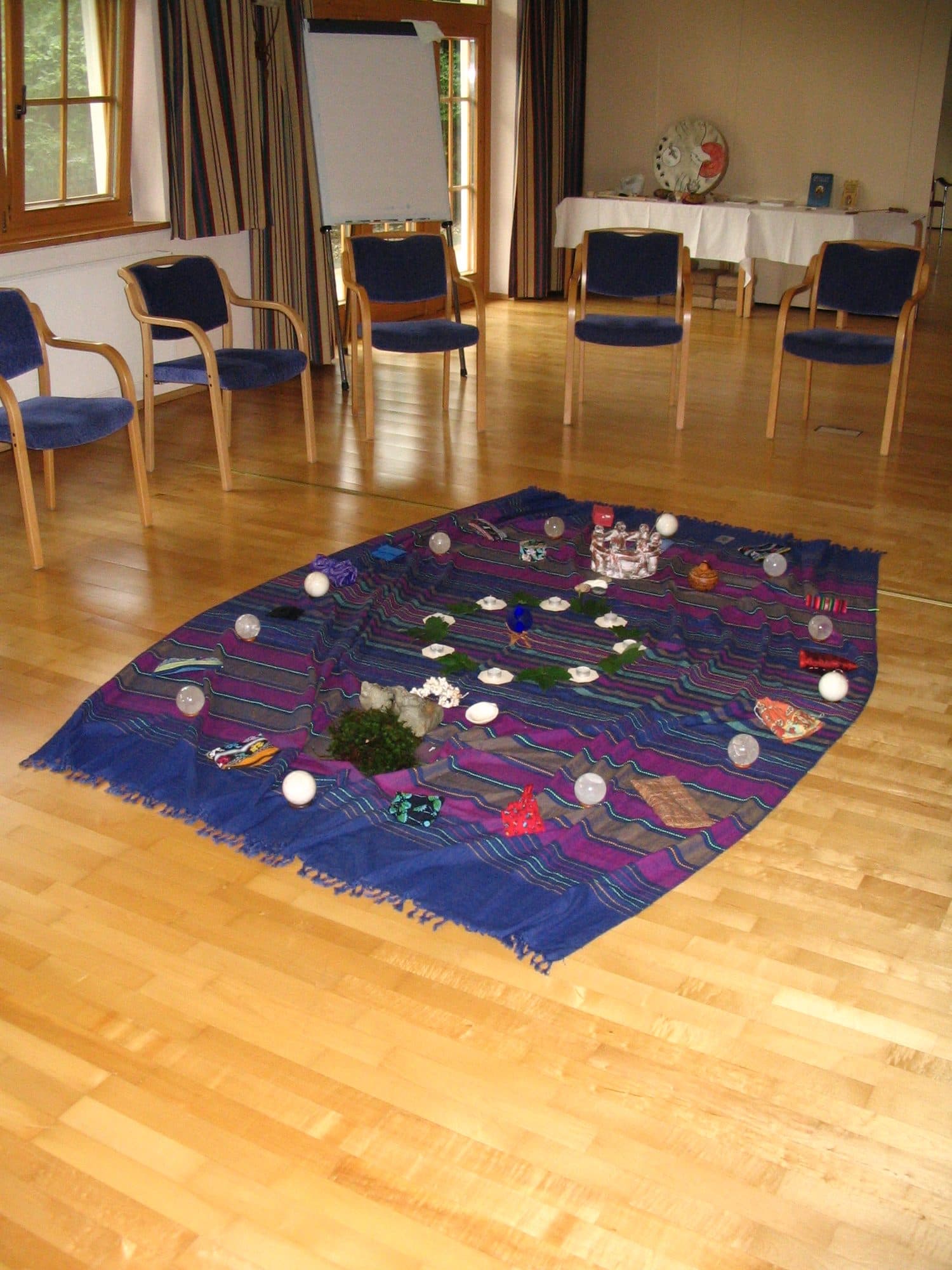 Een opstelling met stenen en kaarsen op een kleed in de zaal in Reith, juli 2008